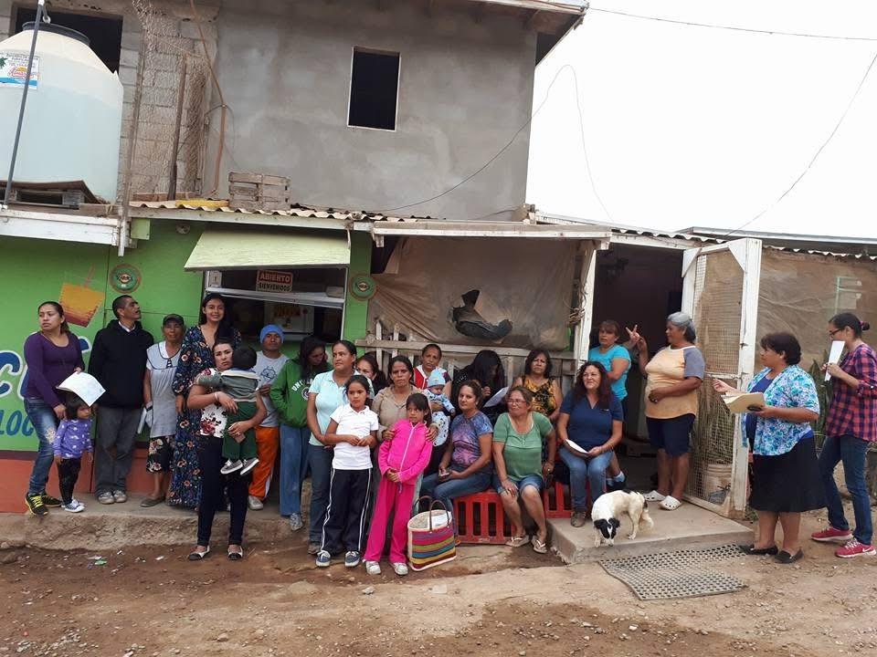 Vecinos reunidos frente a una casa con tinaco en una colonia del Valle.
