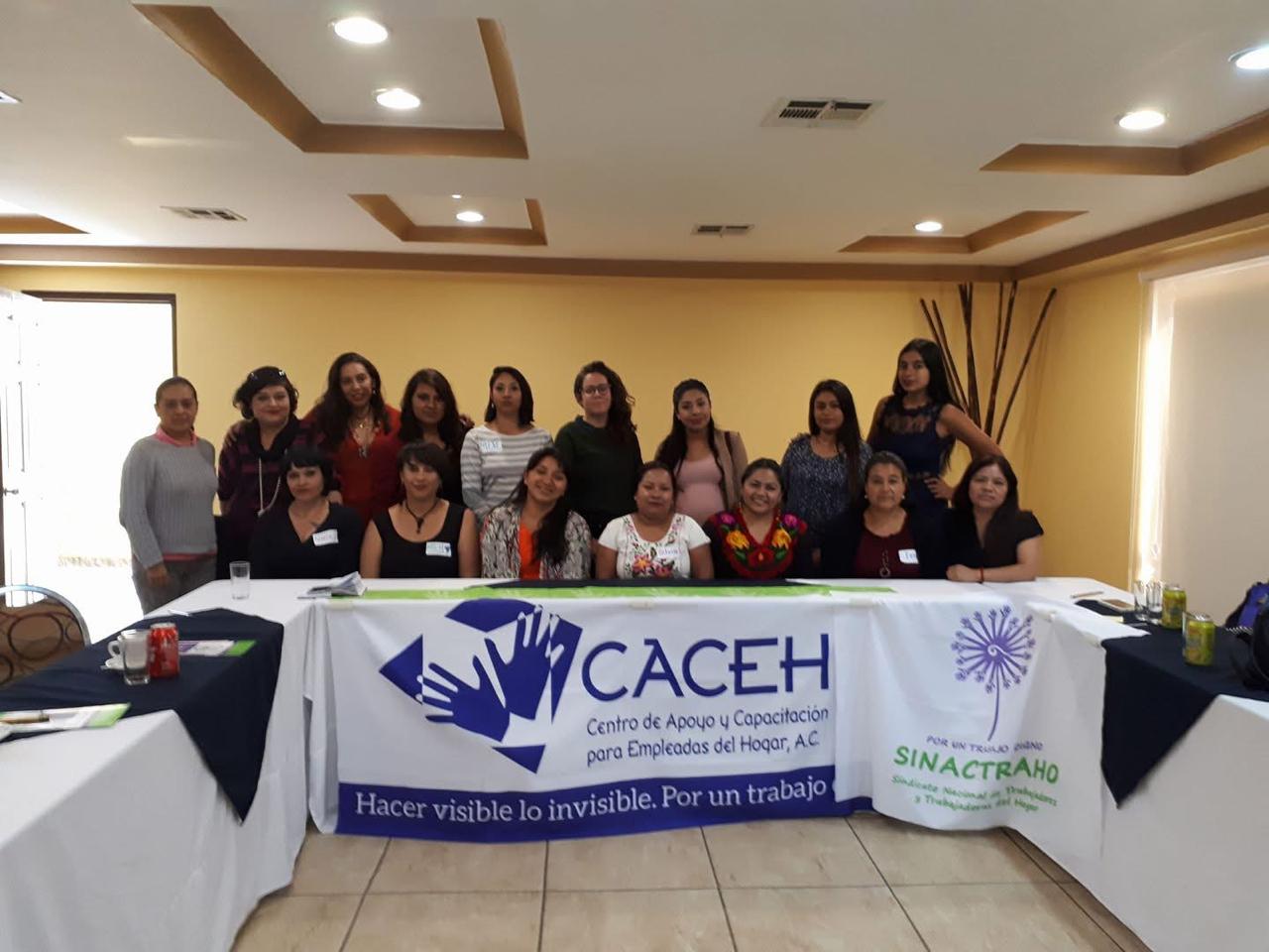 Grupo con lonas de CACEH y SINACTRAHO en un foro por los derechos de las empleadas del hogar.