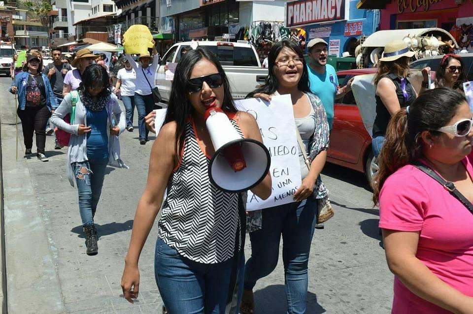 Aurora Inzunza con megáfono al frente de una marcha por los derechos de las mujeres.